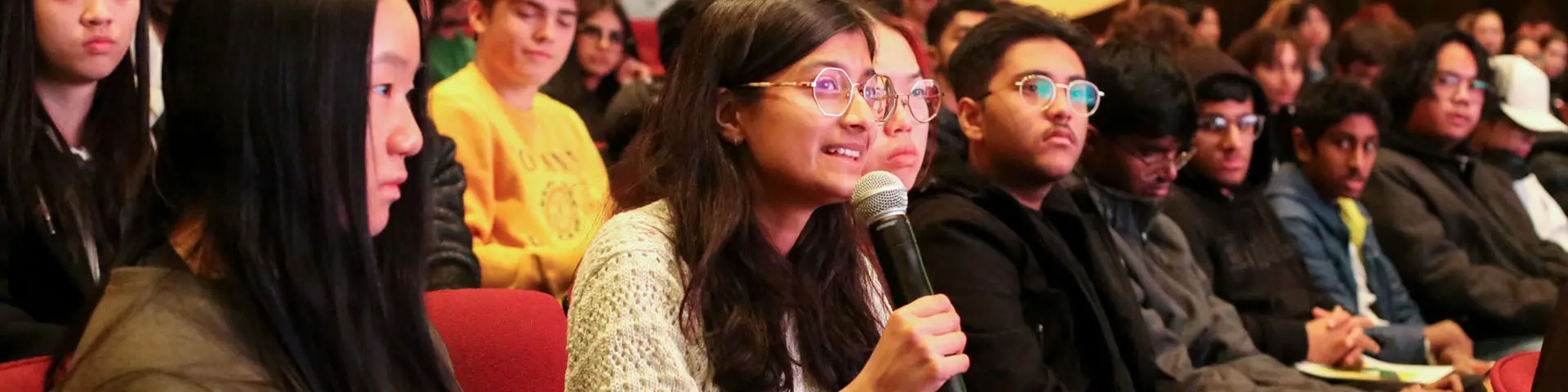 Students in lecture hall engaging in conversation with presenter